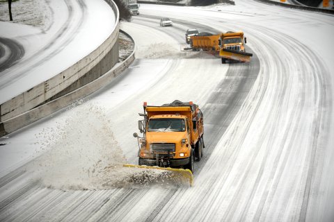 Snow plows clear downtown lanes on Interstate 75/85 during a winter storm on Feb. 12, 2014, in Atlanta. 
