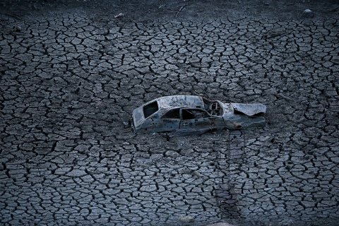 A car sits in dried and cracked earth of what was the bottom of the Almaden Reservoir on Jan. 28, 2014 in San Jose, Calif. 