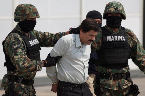 Joaquin "El Chapo" Guzman is escorted to a helicopter in handcuffs by Mexican navy marines at a navy hanger in Mexico City, on Feb. 22, 2014.